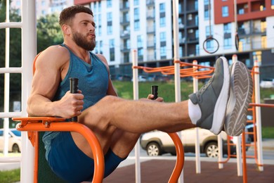 Man training on abs station at outdoor gym