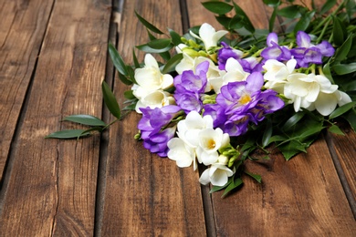 Beautiful freesia bouquet on wooden background