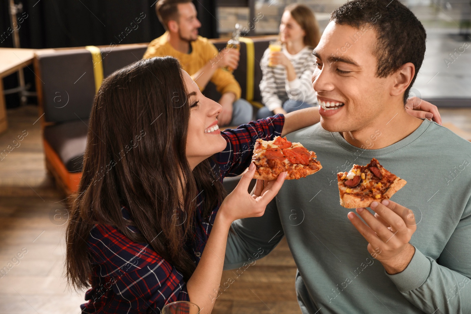 Photo of Young couple eating delicious pizza in cafe