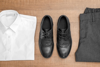 Photo of School uniform for boy on wooden background, top view