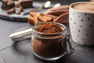 Photo of Jar of cocoa powder on grey table