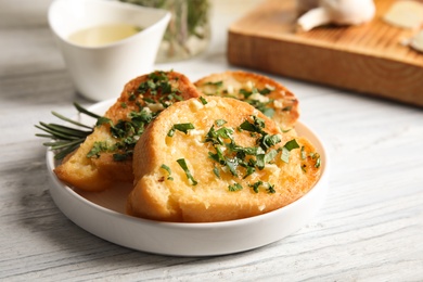 Plate with delicious homemade garlic bread on table. Space for text