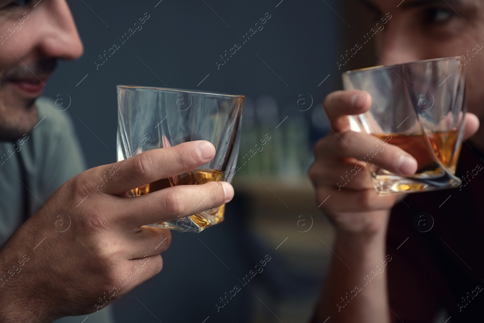 Photo of Young men drinking whiskey together in bar