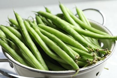 Photo of Fresh green beans in colander, closeup view