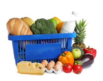 Photo of Shopping basket and grocery products on white background