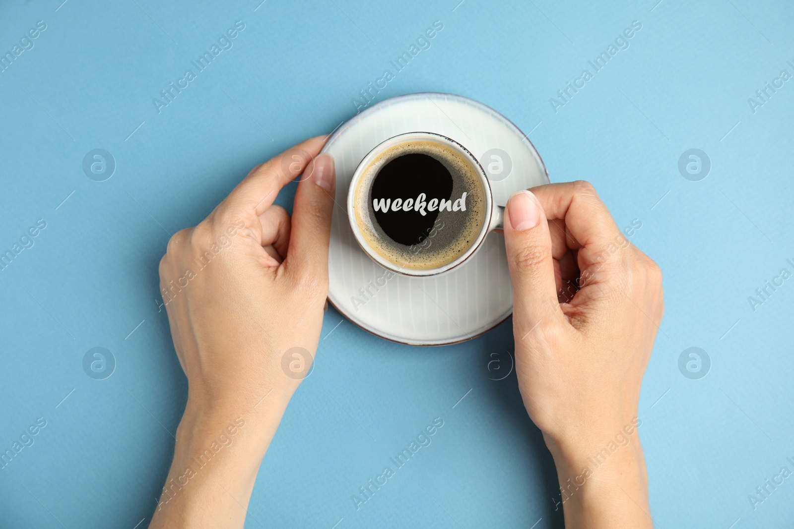 Image of Happy Weekend. Woman with cup of hot aromatic espresso on light blue background, top view