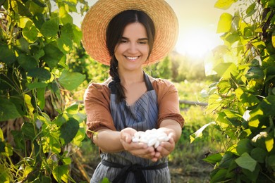 Woman holding white beans in hands outdoors