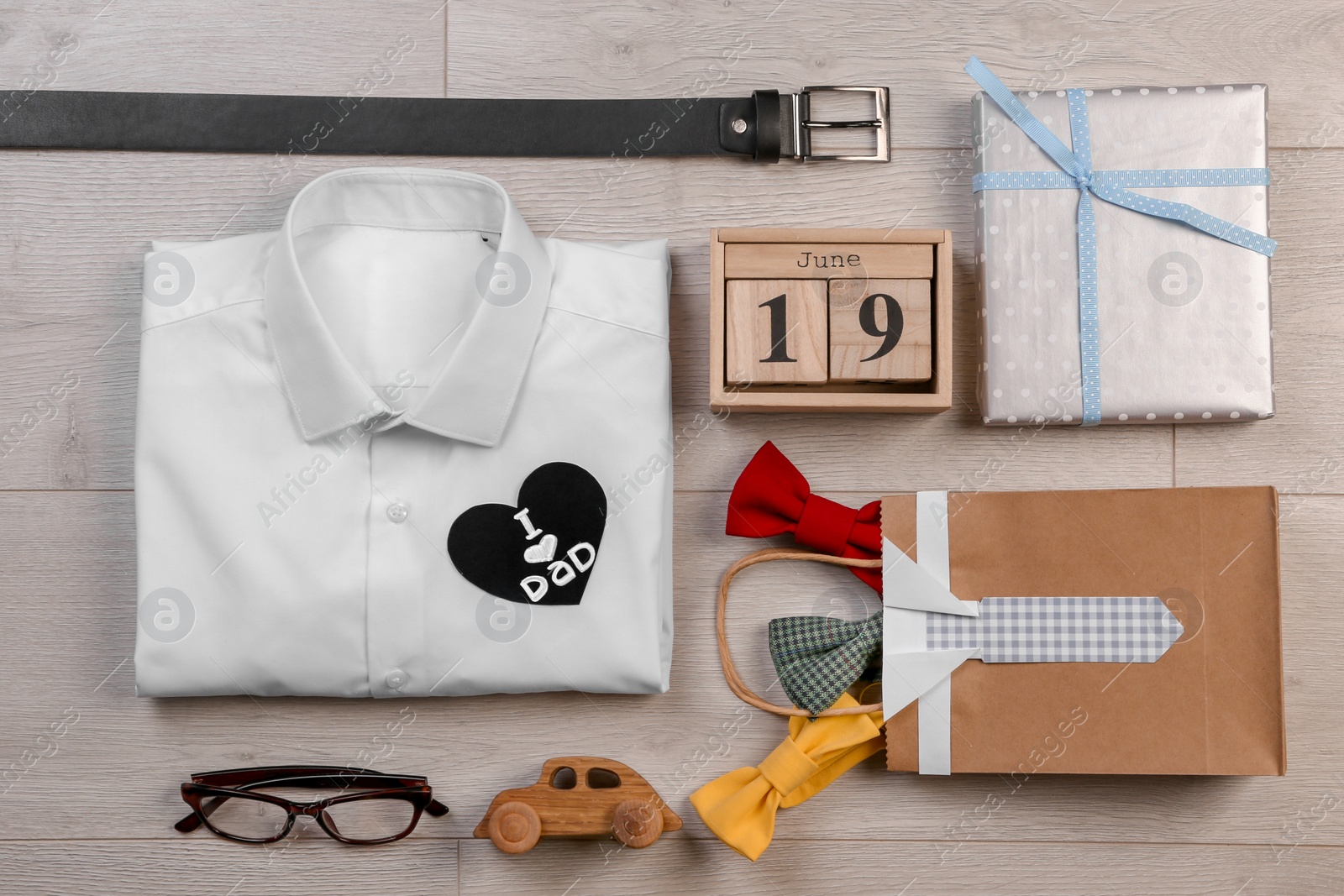 Photo of Composition with calendar, shirt and gifts on wooden background. Father's day celebration