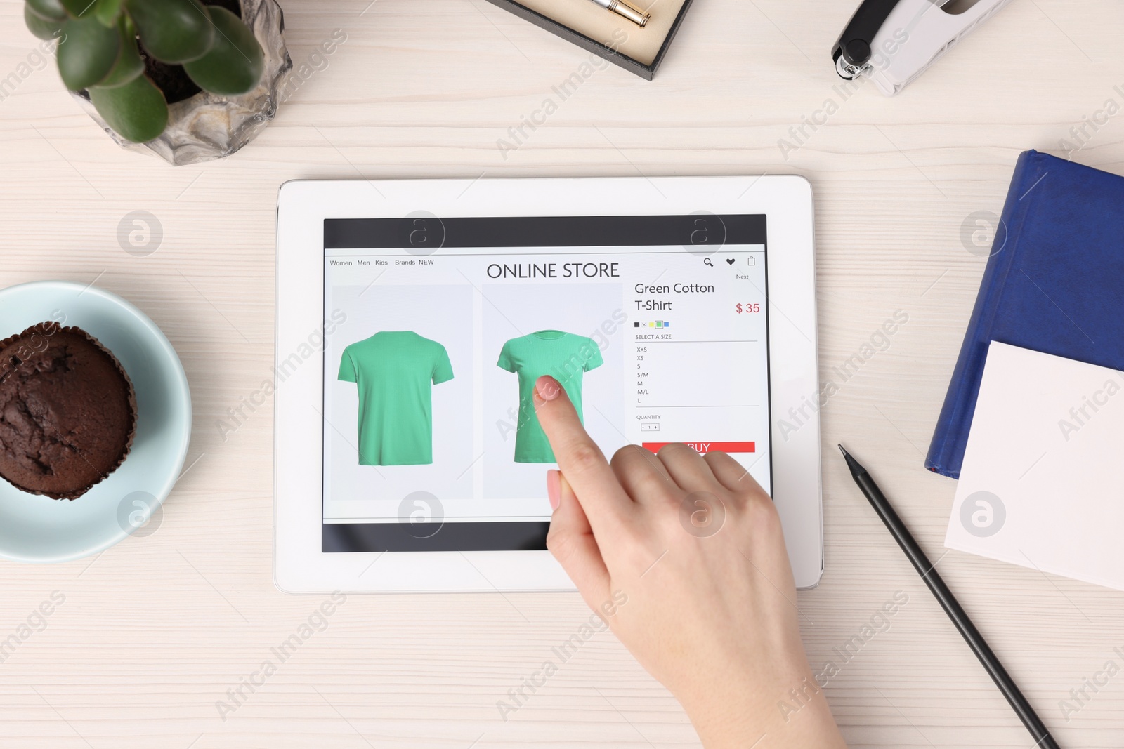 Photo of Woman with tablet shopping online at white wooden table, top view