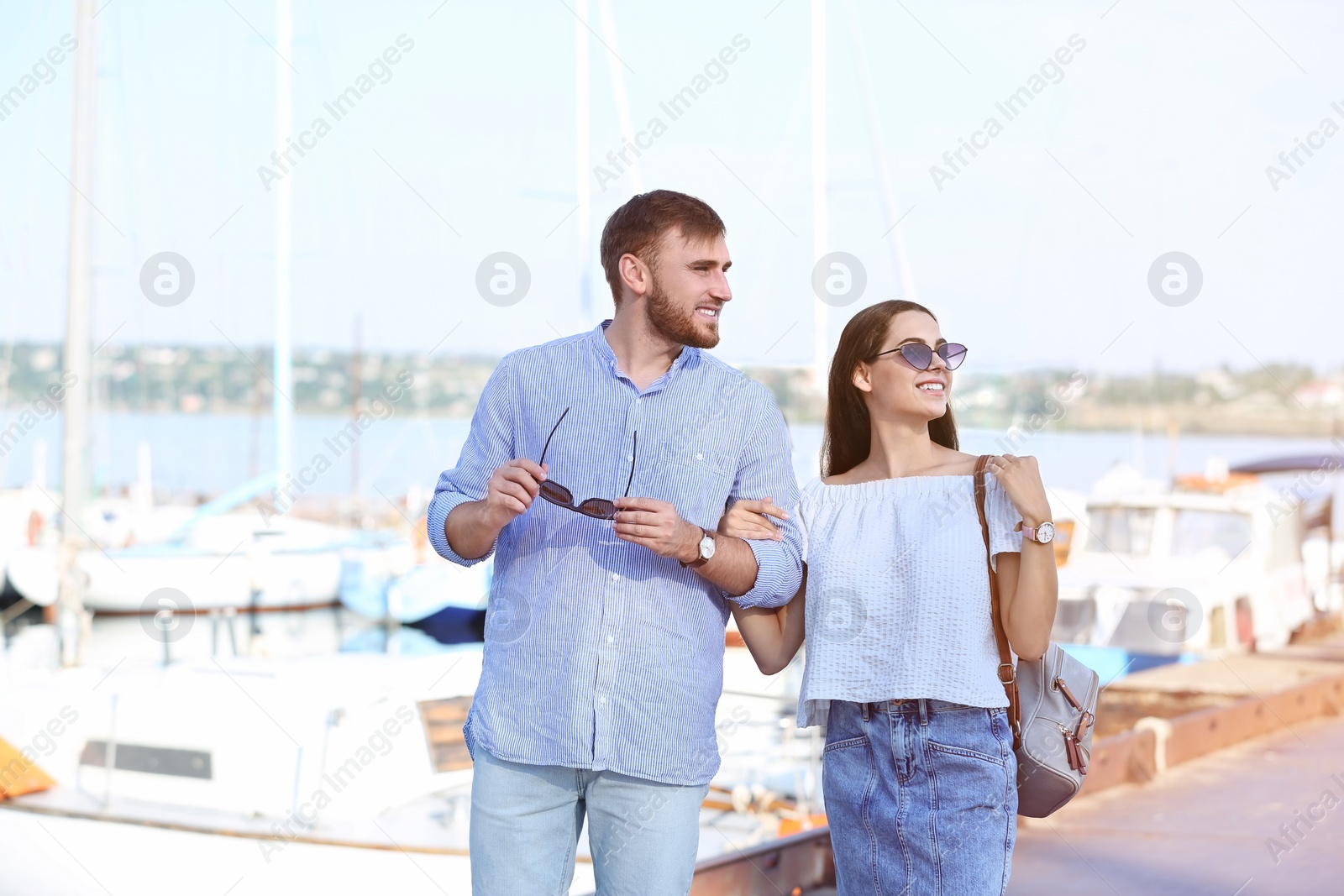 Photo of Young hipster couple in jean clothes on pier