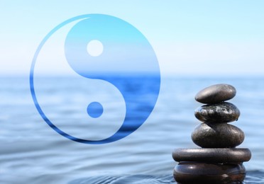 Image of Stack of stones in water and Ying Yang symbol. Feng Shui philosophy 