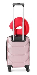 Photo of Red travel pillow on suitcase against white background