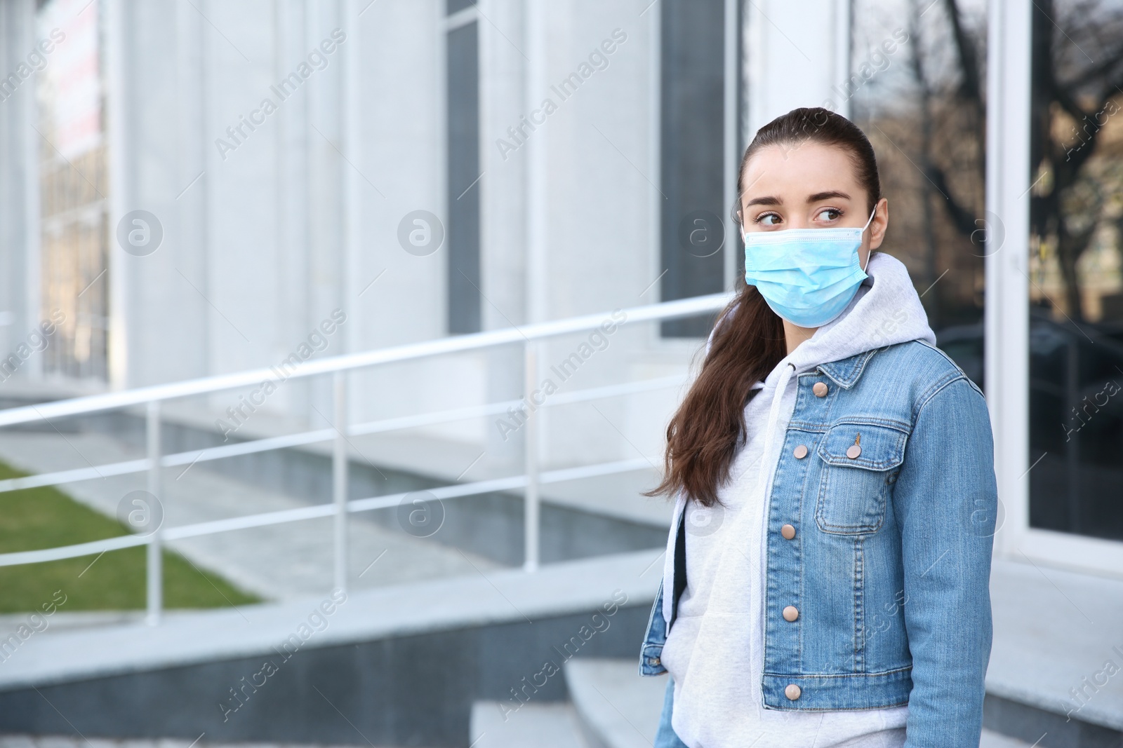 Photo of Woman wearing disposable mask outdoors. Dangerous virus