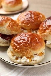Photo of Freshly baked soda water scones with jam and butter on table, closeup