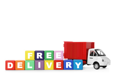Toy truck and cubes with words FREE DELIVERY isolated on white. Logistics and wholesale concept