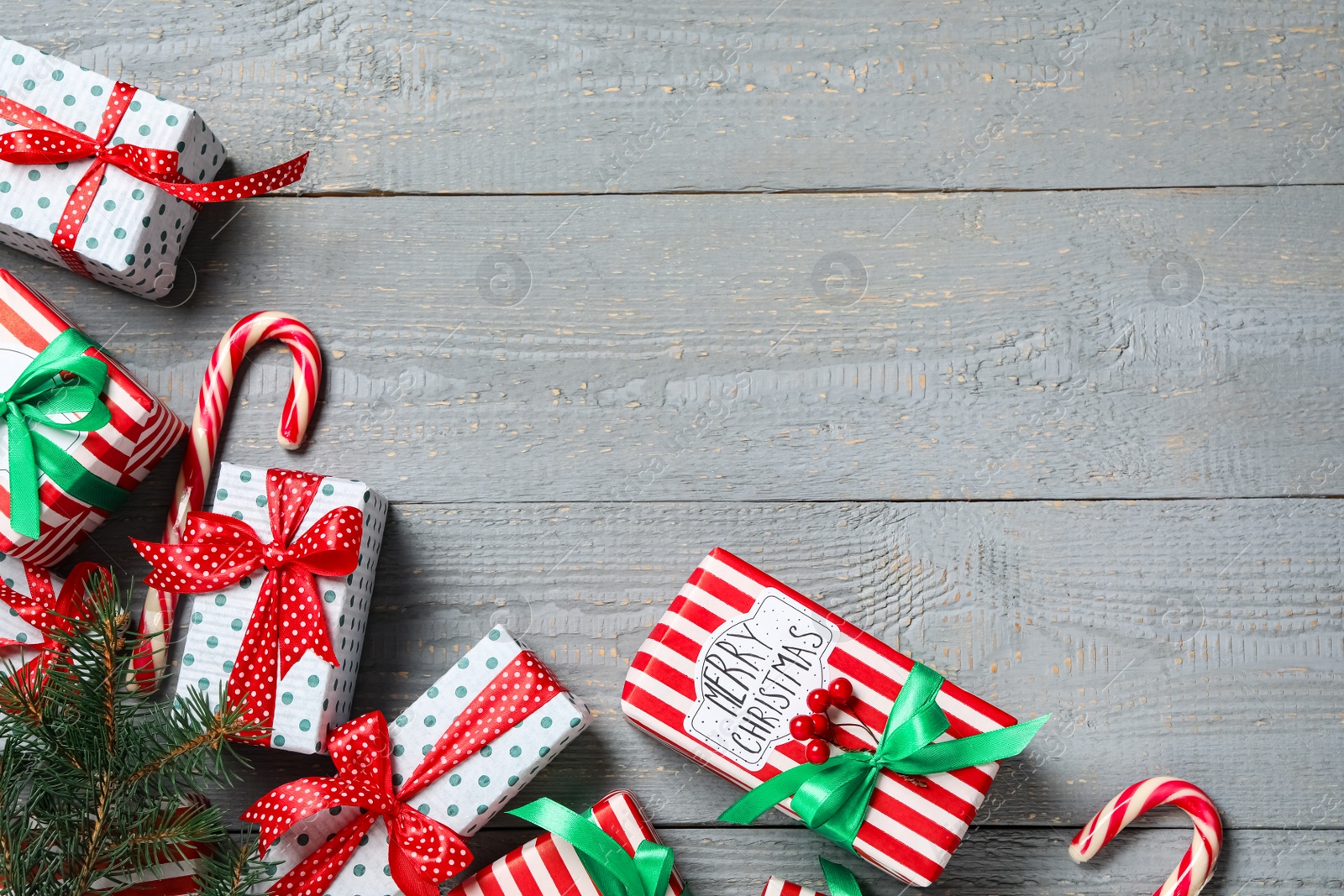 Photo of Christmas gift boxes on grey wooden background, flat lay. Space for text