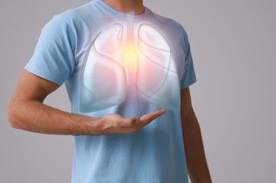 Image of Man holding hand near chest with illustration of lungs on grey background, closeup
