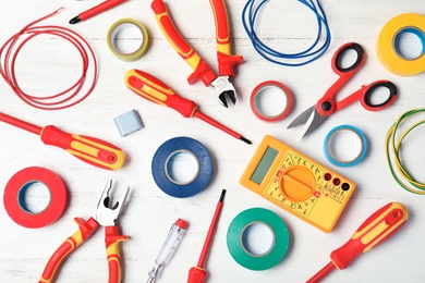 Flat lay composition with electrician's tools on wooden background