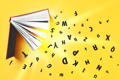 Image of Letters flying out from open book on yellow background, top view