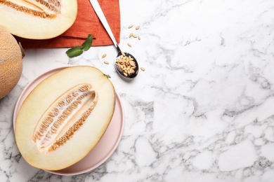Photo of Delicious honey melon on white marble table, flat lay. Space for text