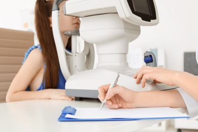 Ophthalmologist examining little girl in clinic