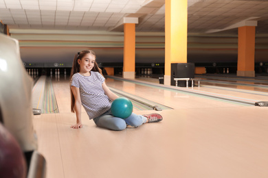 Photo of Preteen girl with ball in bowling club