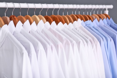 Rack with clean clothes on hangers after dry-cleaning