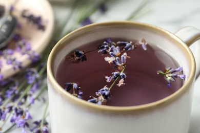 Photo of Fresh delicious tea with lavender in mug, closeup