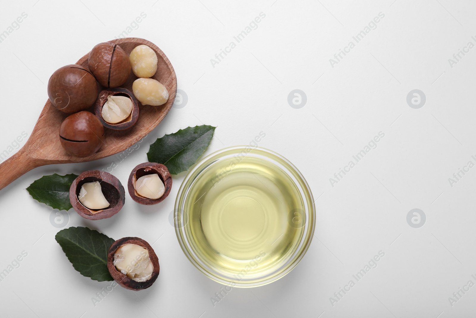 Photo of Delicious organic Macadamia nuts and natural oil on white background, flat lay. Space for text