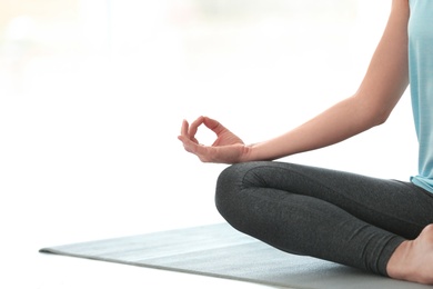 Photo of Beautiful woman meditating indoors, space for text. Zen yoga