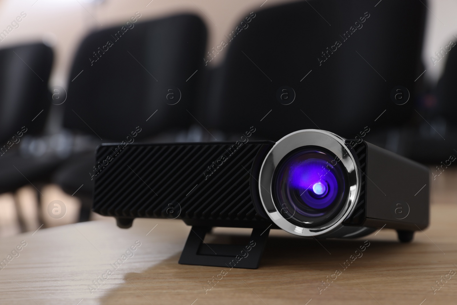 Photo of Modern video projector on table in conference room