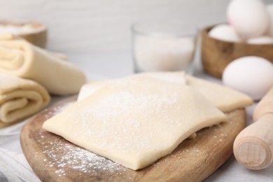 Photo of Raw puff pastry dough on table, closeup