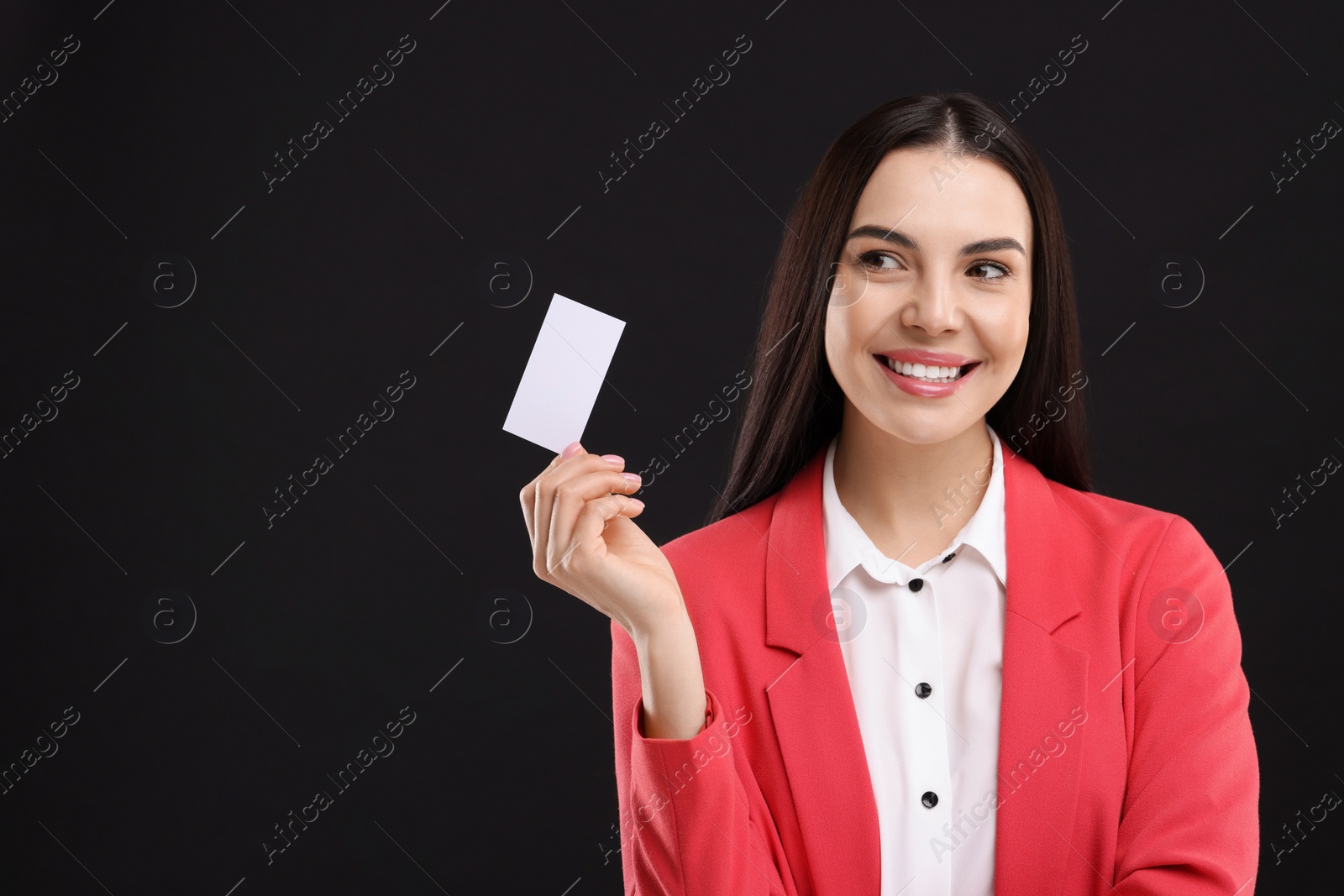 Photo of Happy woman holding blank business card on black background. Space for text