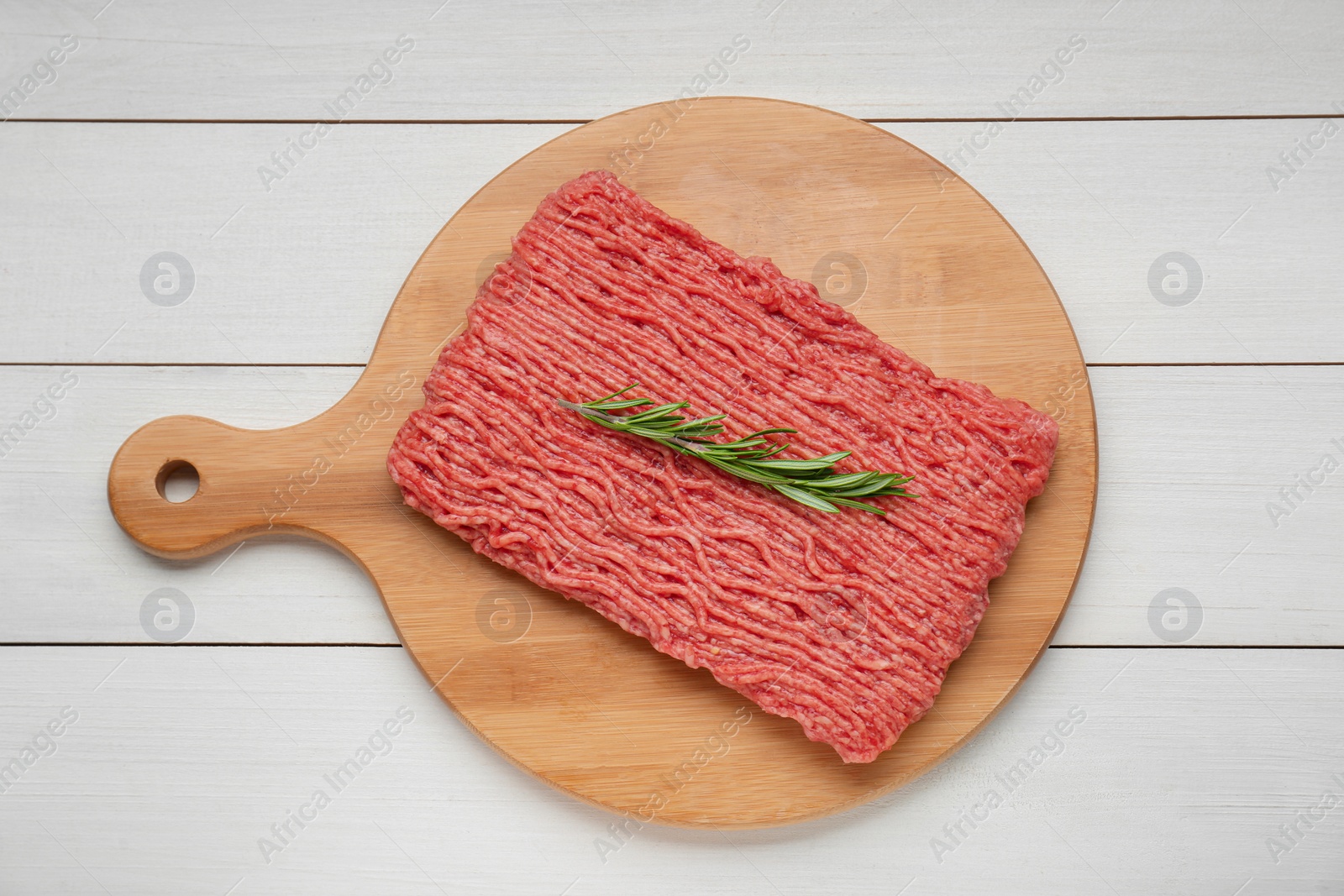 Photo of Raw fresh minced meat with rosemary on white wooden table, top view