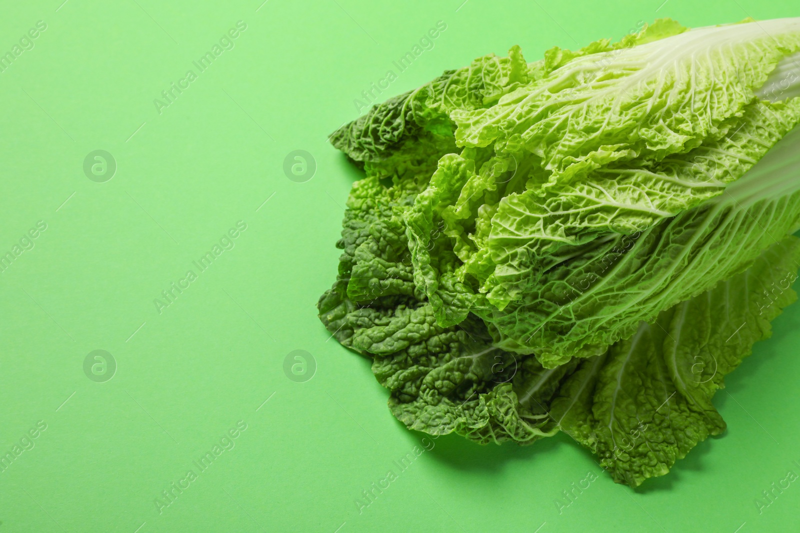 Photo of Fresh ripe Chinese cabbage on light green background, closeup. Space for text