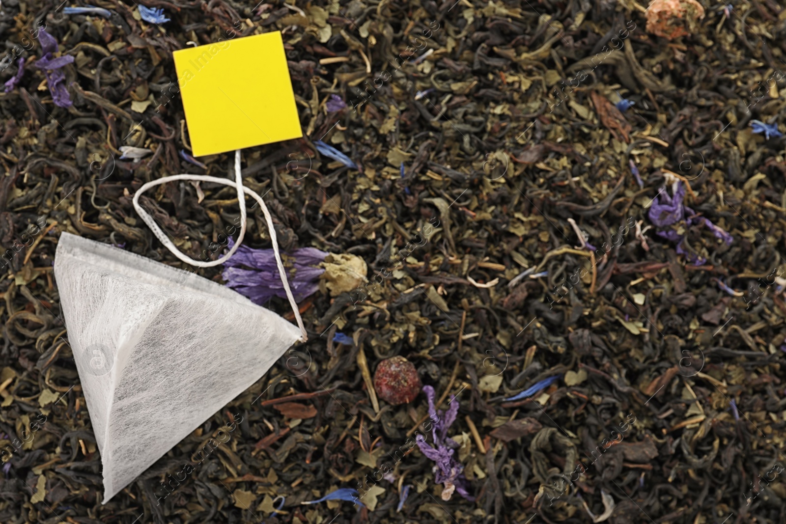 Photo of Tea bag on dry leaves, top view with space for text