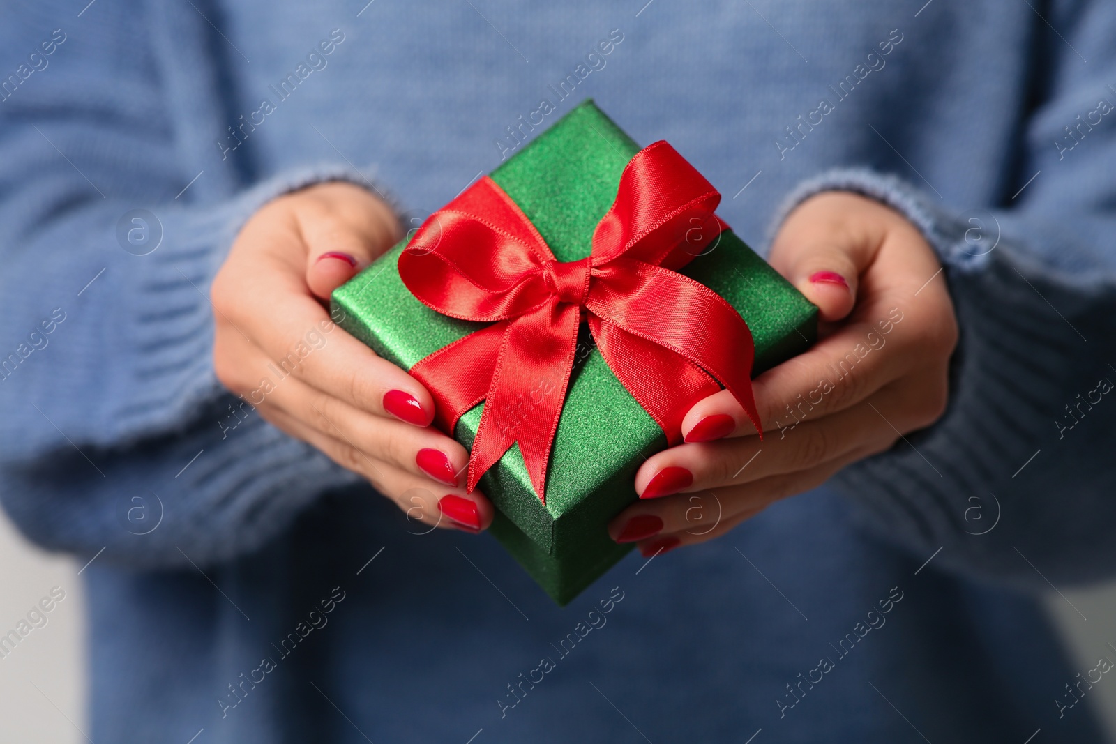 Photo of Christmas present. Woman holding gift box, closeup