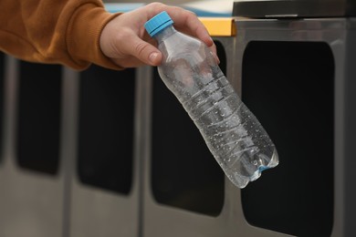 Man throwing plastic bottle into sorting bin, closeup