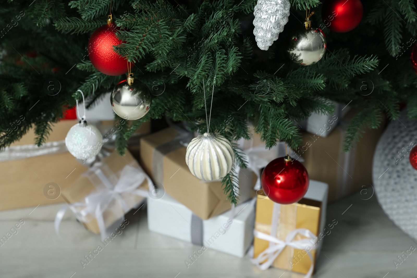 Photo of Beautifully decorated Christmas tree and many gift boxes in room