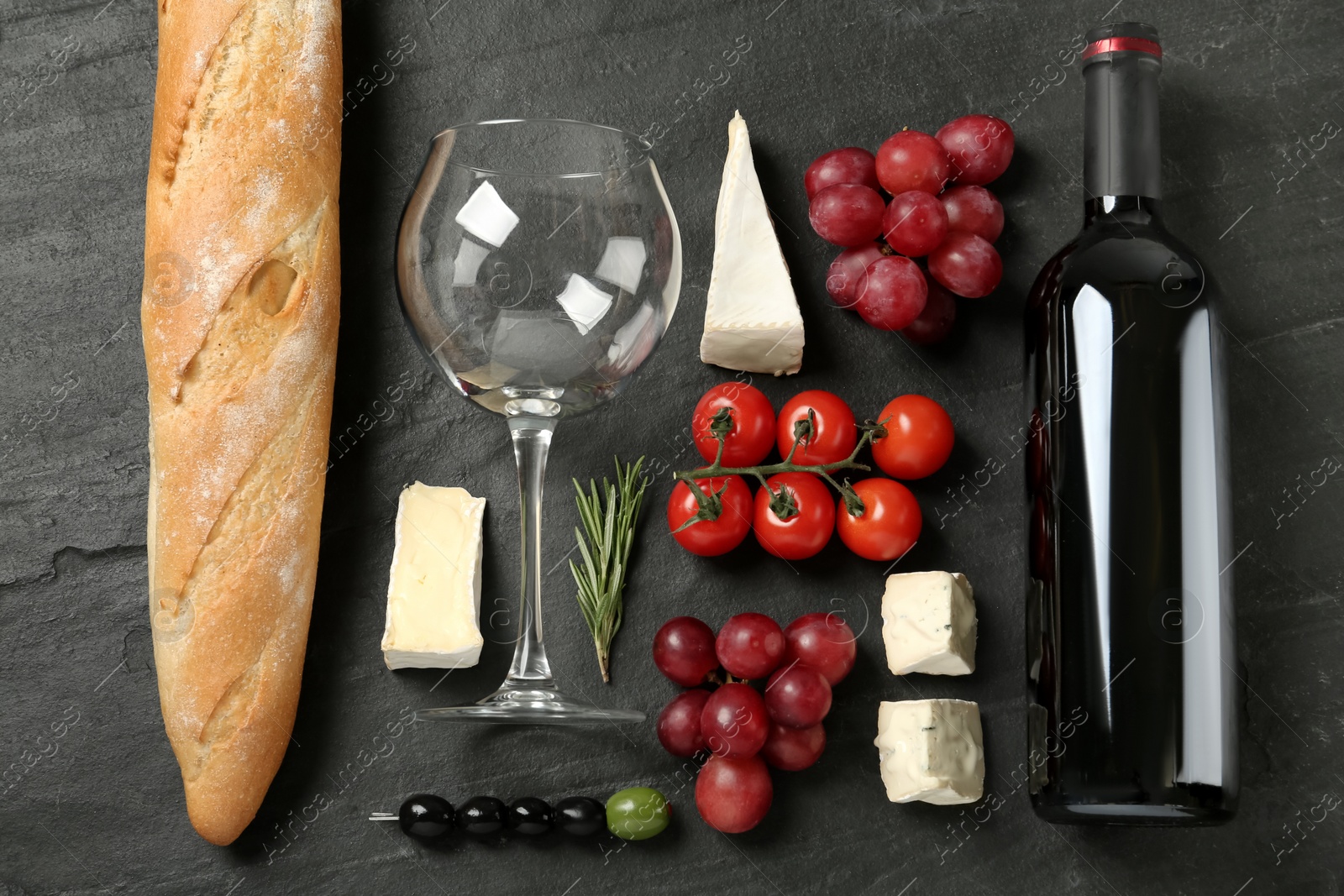 Photo of Flat lay composition with red wine and snacks on black table