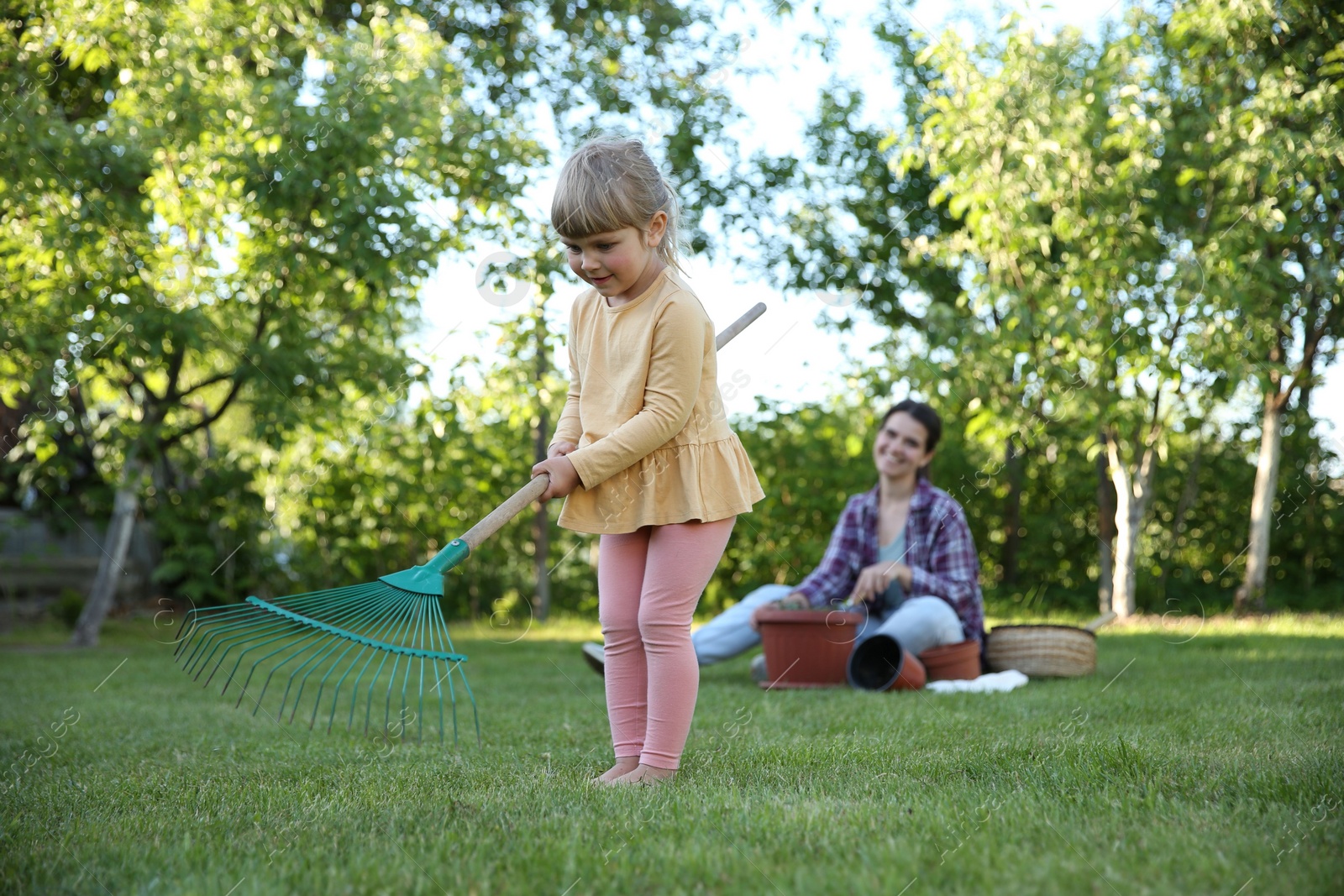 Photo of Mother and her daughter working together in garden