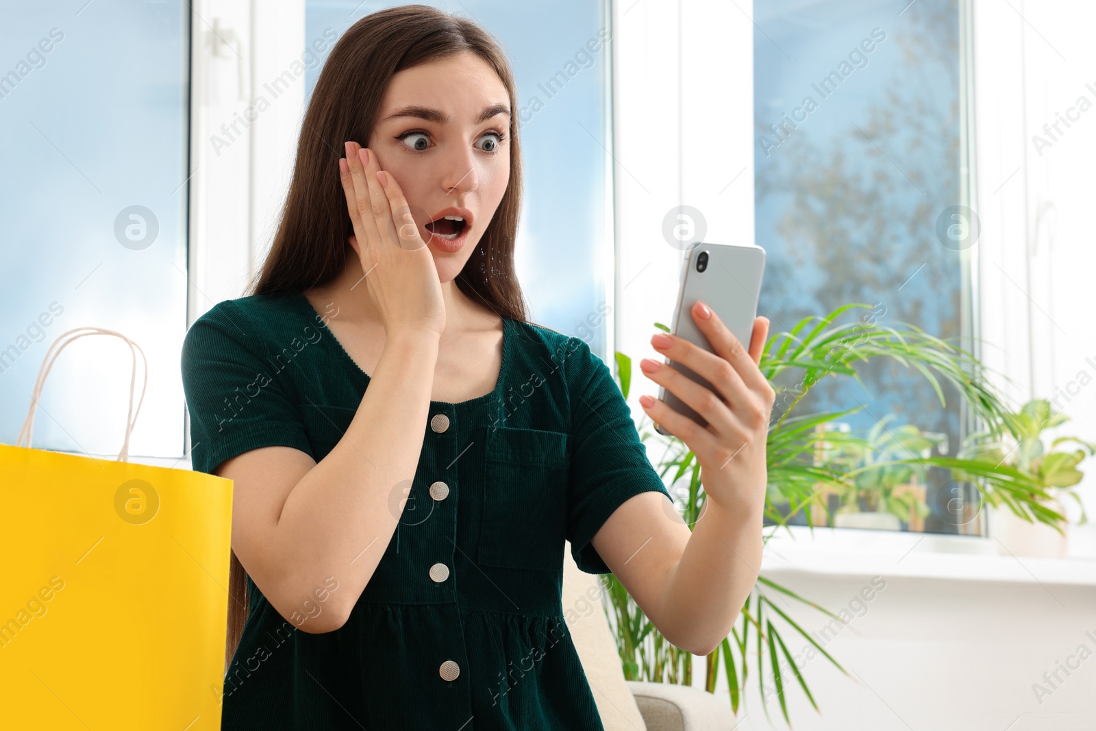 Photo of Special Promotion. Emotional woman looking at smartphone near window indoors