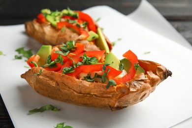 Photo of Stuffed sweet potatoes served on parchment, closeup