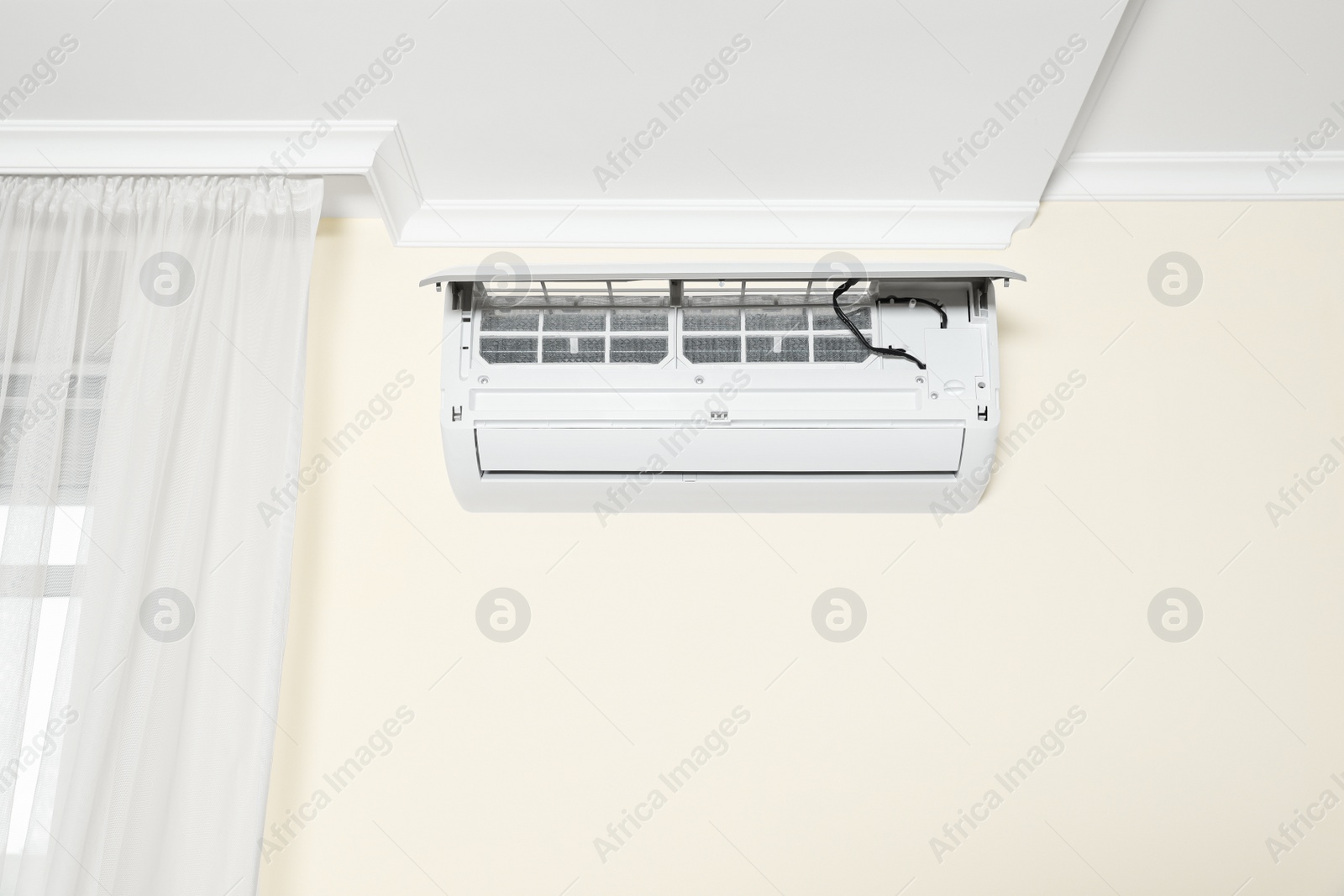 Photo of Modern air conditioner on white wall indoors