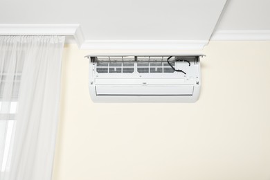 Modern air conditioner on white wall indoors