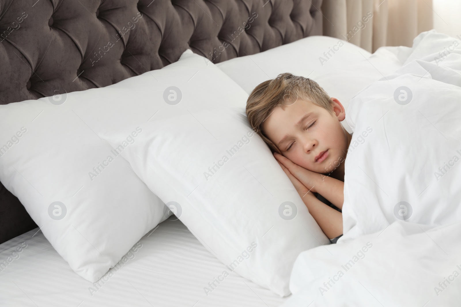 Photo of Cute tired boy sleeping in comfortable bed