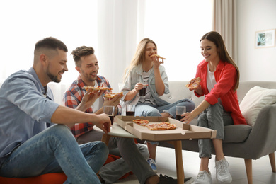 Group of friends eating tasty pizza at home