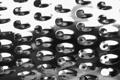 Modern metal grater as background, top view