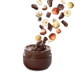 Making yummy chocolate paste. Hazelnuts and pieces of chocolate falling into jar on white background