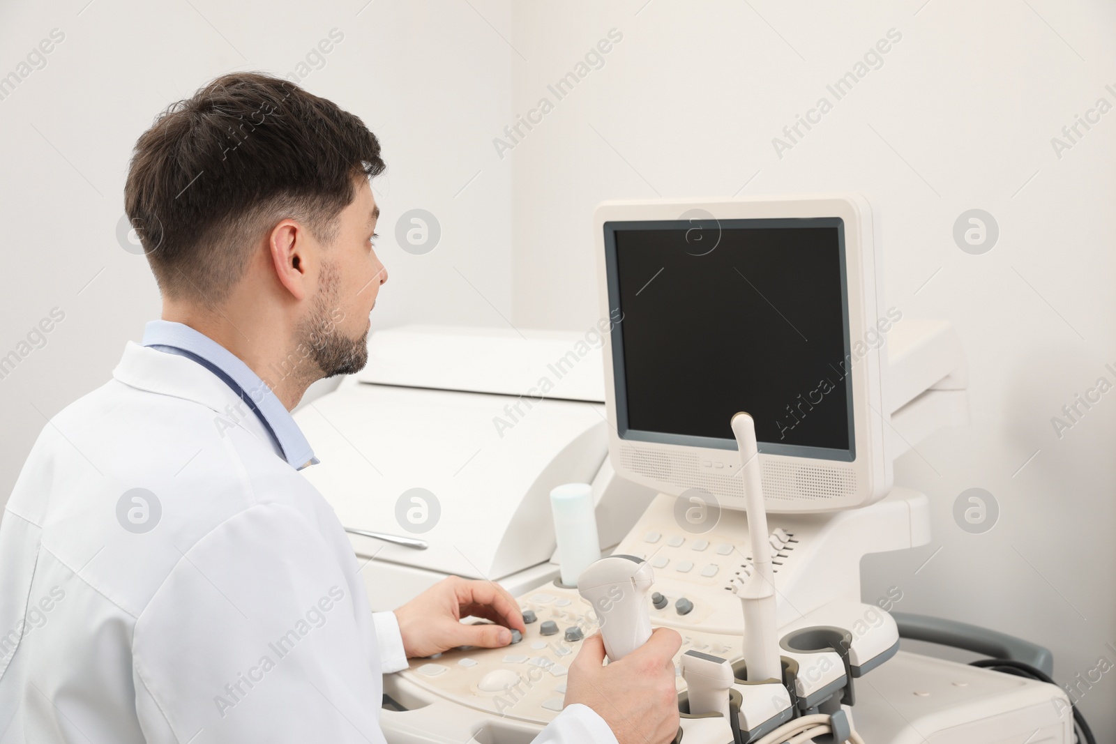 Photo of Sonographer operating modern ultrasound machine in clinic